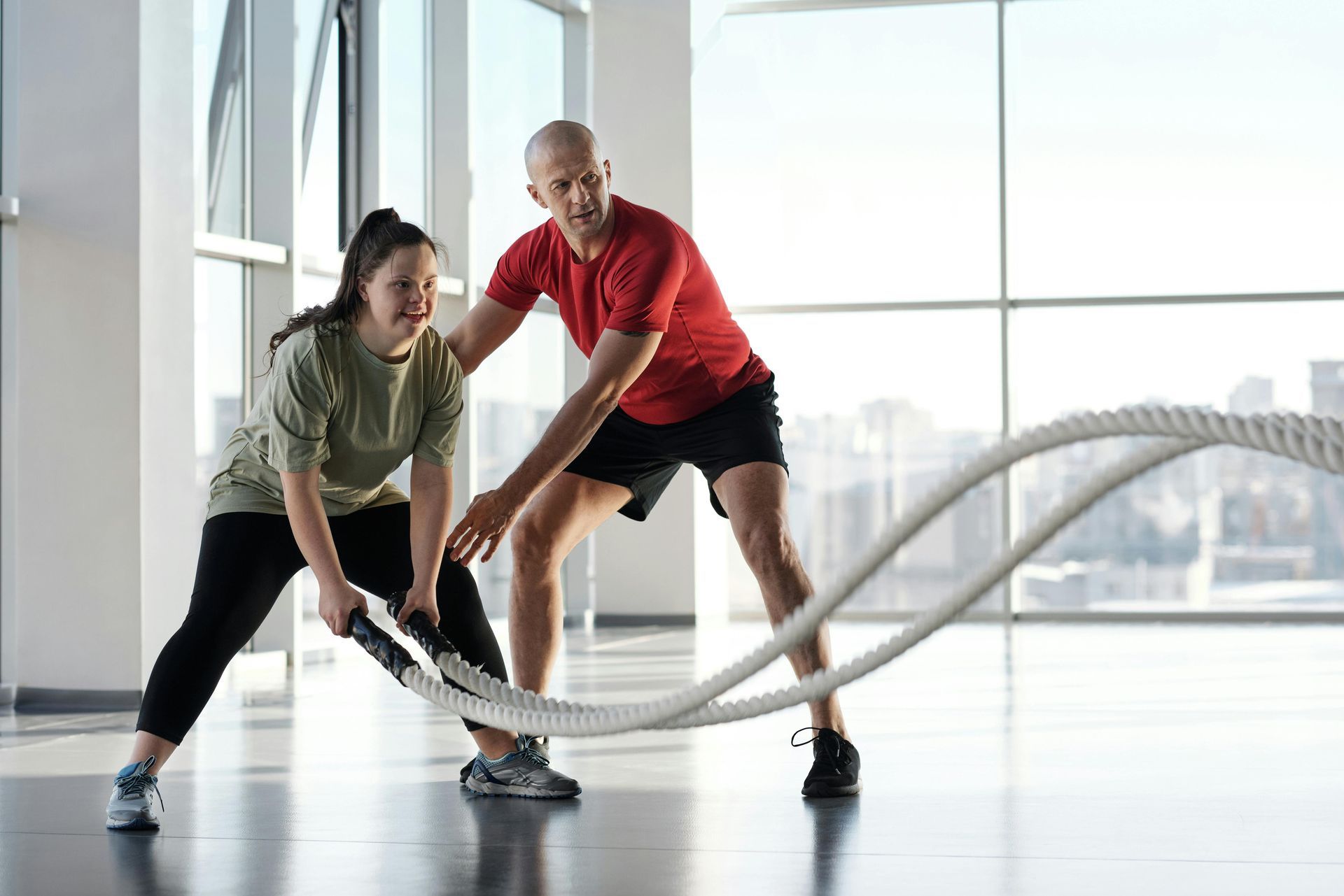 two people training with rope in gym