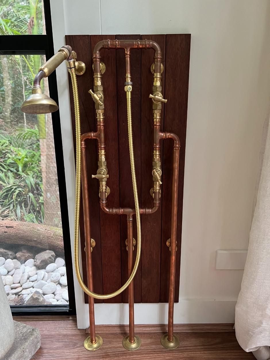 A Shower Head Is Attached To A Copper Pipe In A Bathroom — Etosha Plumbing & Gasfitting In Alstonville, NSW