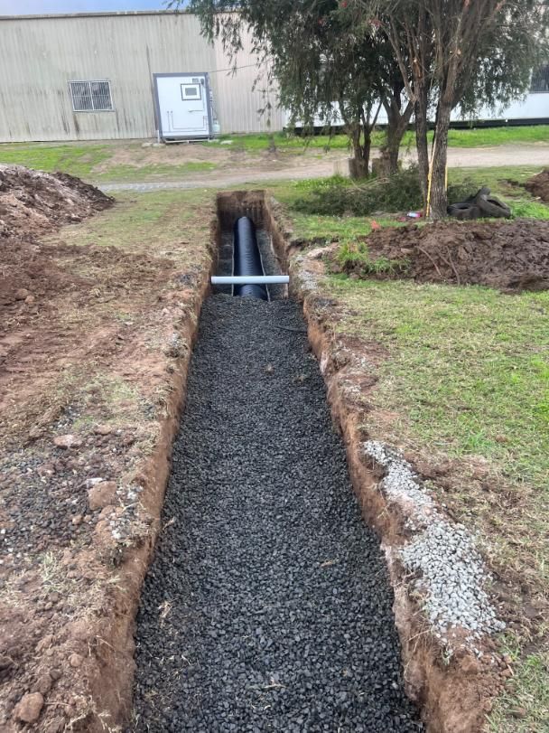 A Pipe Is Being Installed In A Trench In The Ground — Etosha Plumbing & Gasfitting In Lismore, NSW