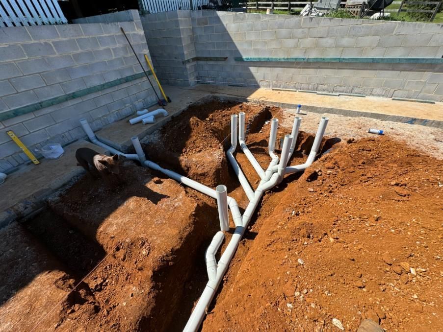 A Bunch Of Pipes Are Laying In The Dirt — Etosha Plumbing & Gasfitting In Alstonville, NSW
