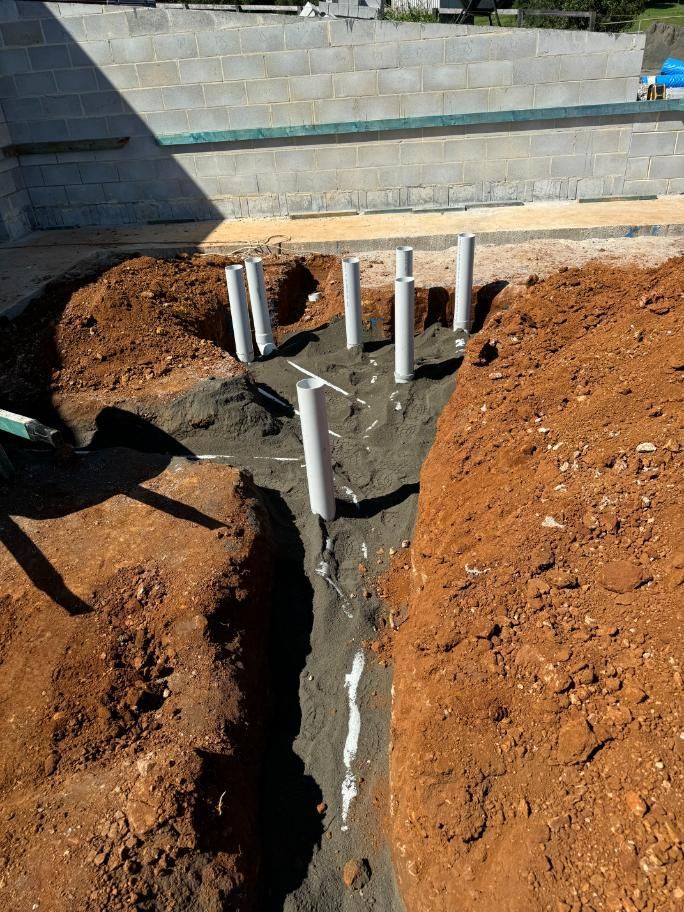 A Group Of Pipes Are Being Installed In A Hole In The Ground  — Etosha Plumbing & Gasfitting In Byron Bay, NSW