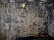 Close-up of a rough stone wall with a small date stamp at the bottom right.