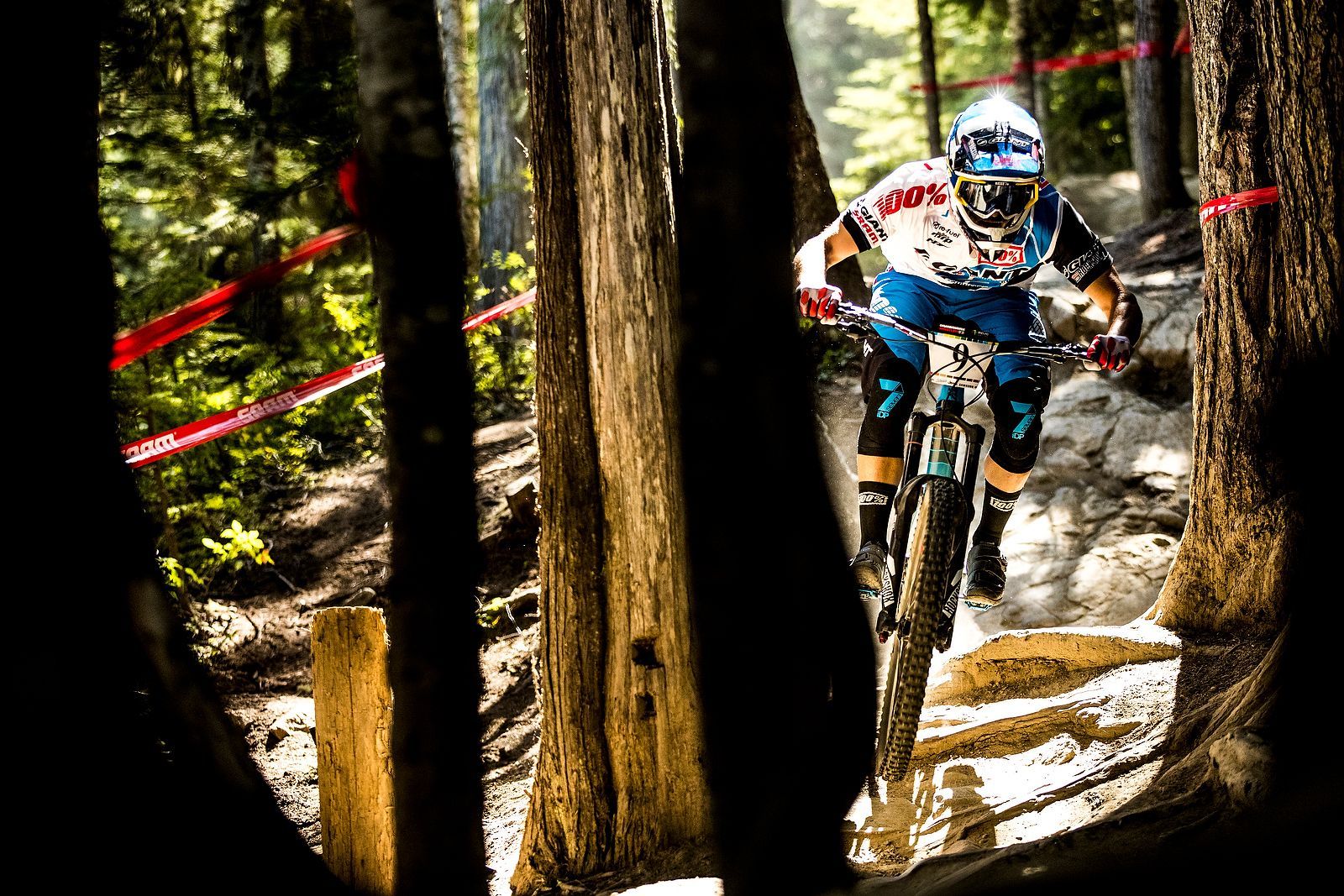 A man is riding a mountain bike down a trail in the woods.