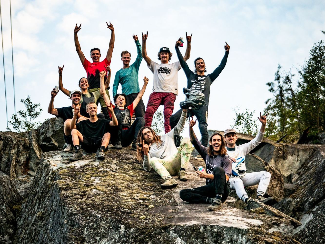 A group of people are posing for a picture on top of a rock.