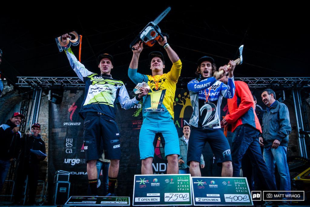 A group of men are standing on a stage holding a chainsaw.