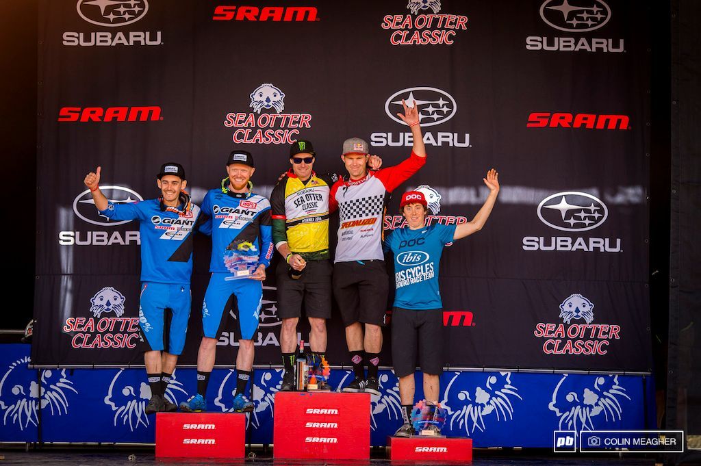 A group of men are standing on a podium in front of a subaru banner.
