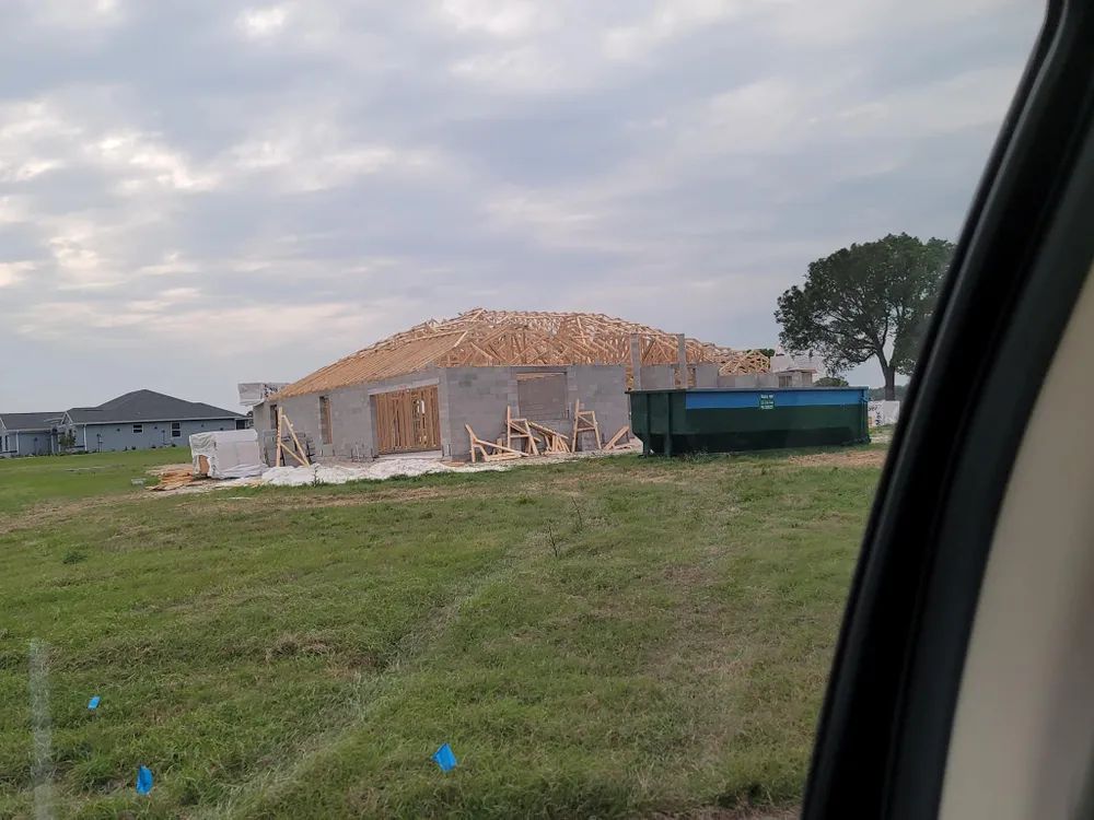 A house is being built in the middle of a grassy field.