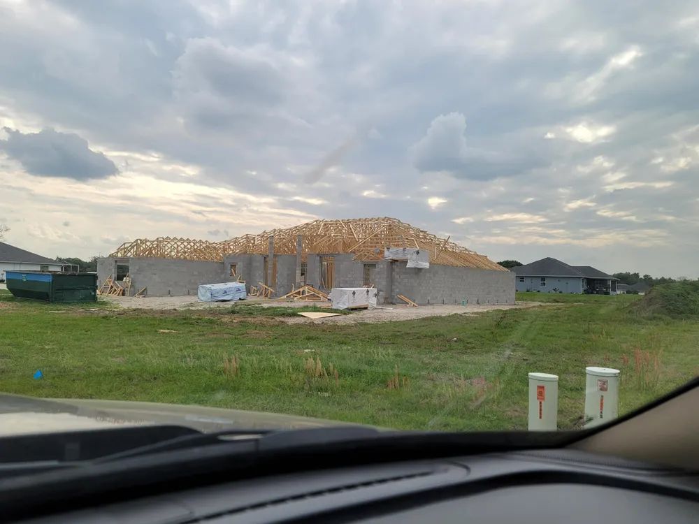 A house is being built in the middle of a field.