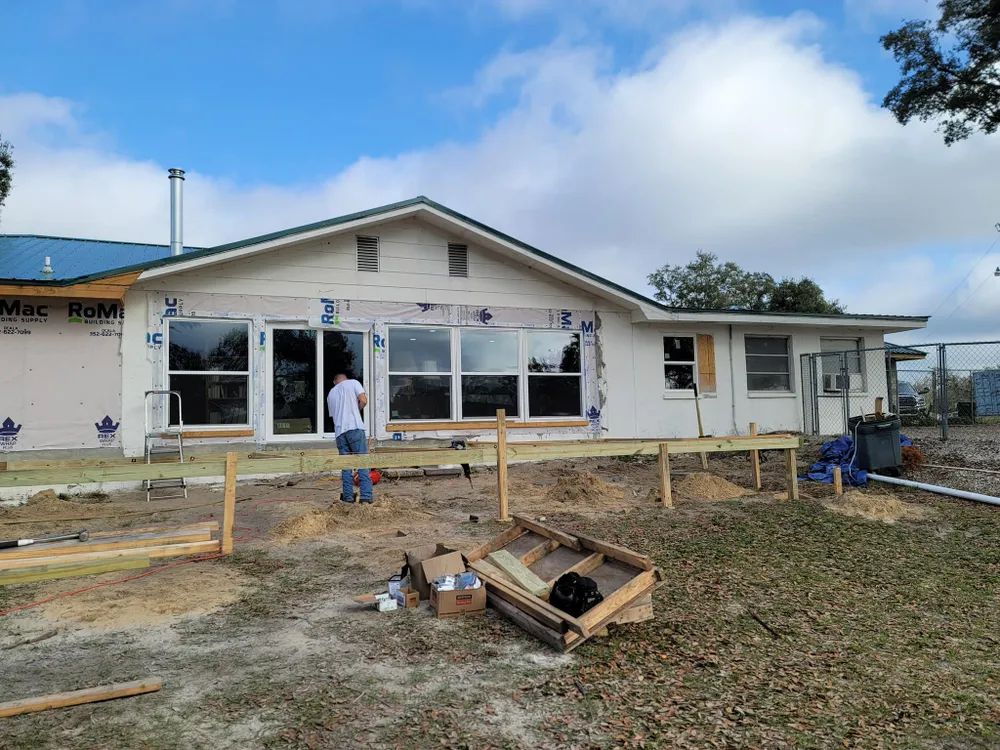 A man is standing in front of a house under construction.