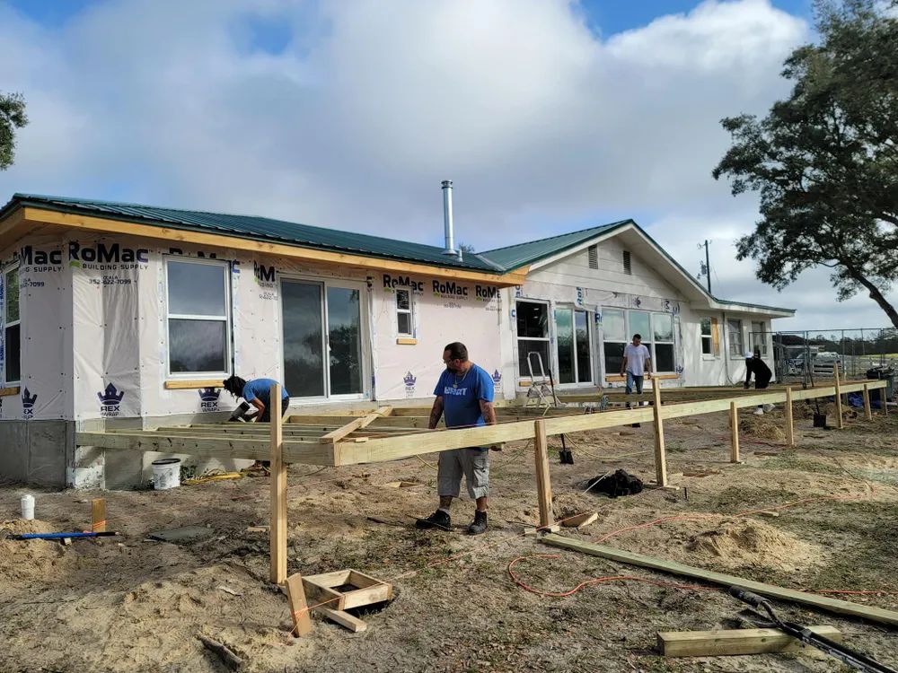 A man is standing in front of a house that is being built.