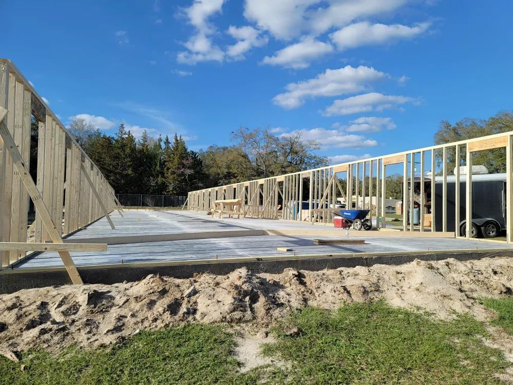 A house is being built in the middle of a dirt field.