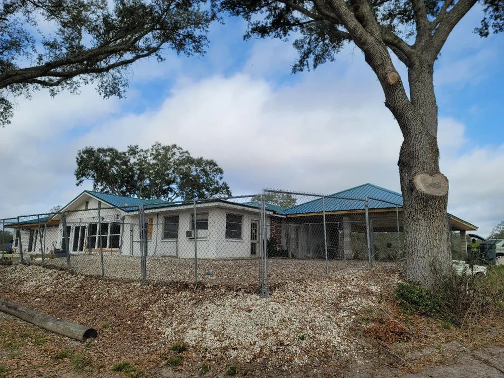 A house with a blue roof and a tree in front of it
