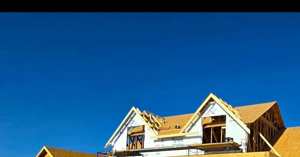 A house under construction with a blue sky in the background