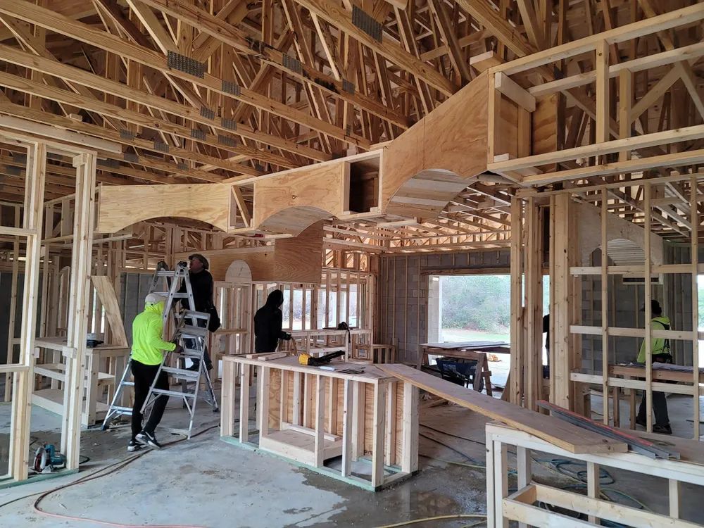 A group of people are working on a house under construction.