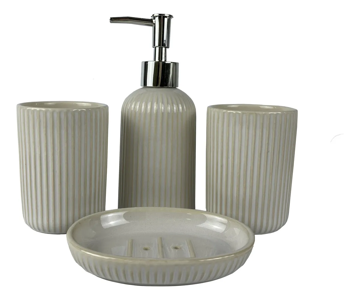 Mano sosteniendo un dispensador de jabón acanalado de color beige con bomba dorada, rodeado de accesorios de baño a juego.