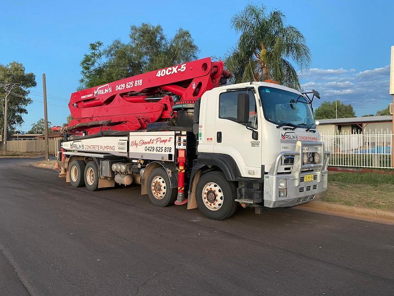A Concrete Pump Truck Is Parked on The Side of The Road — Maslin Concrete Pumping in Forbes, NSW
