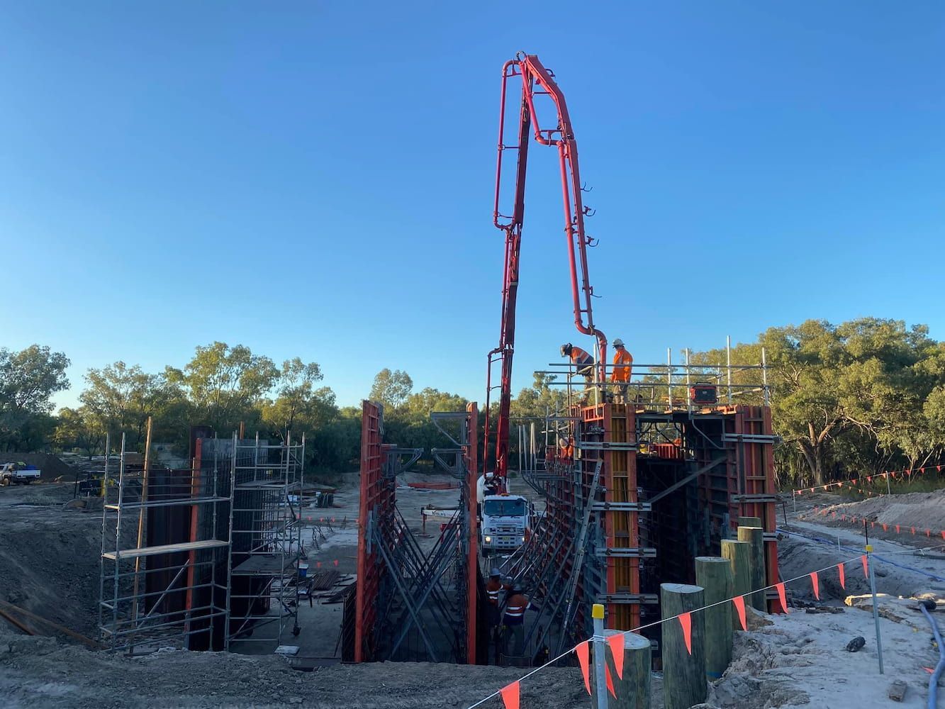 A Concrete Pump Is Being Used to Pour Concrete Into a Hole in The Ground — Maslin Concrete Pumping in Cowra, NSW