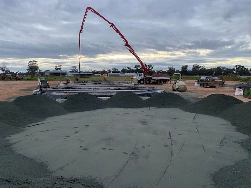 A Concrete Pump Is Being Used to Pour Concrete Into a Large Pile of Dirt — Maslin Concrete Pumping in Forbes, NSW