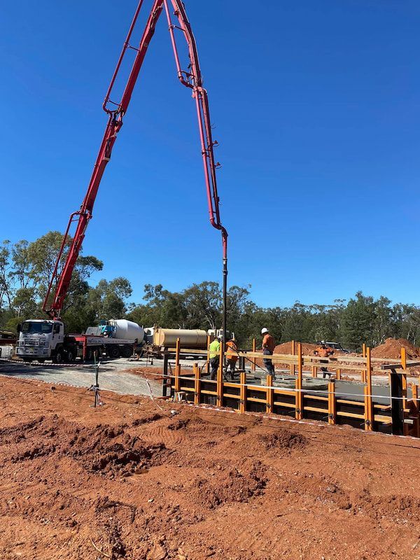 A Concrete Pump Is Being Used to Pour Concrete on A Construction Site — Maslin Concrete Pumping in Forbes, NSW