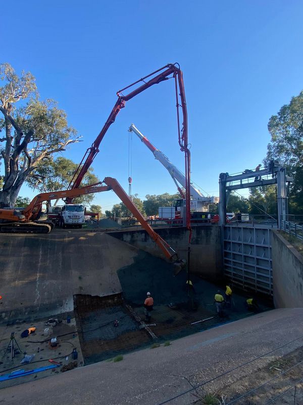 A Crane Is Being Used to Pump Cement Into a Body of Water — Maslin Concrete Pumping in Dubbo, NSW