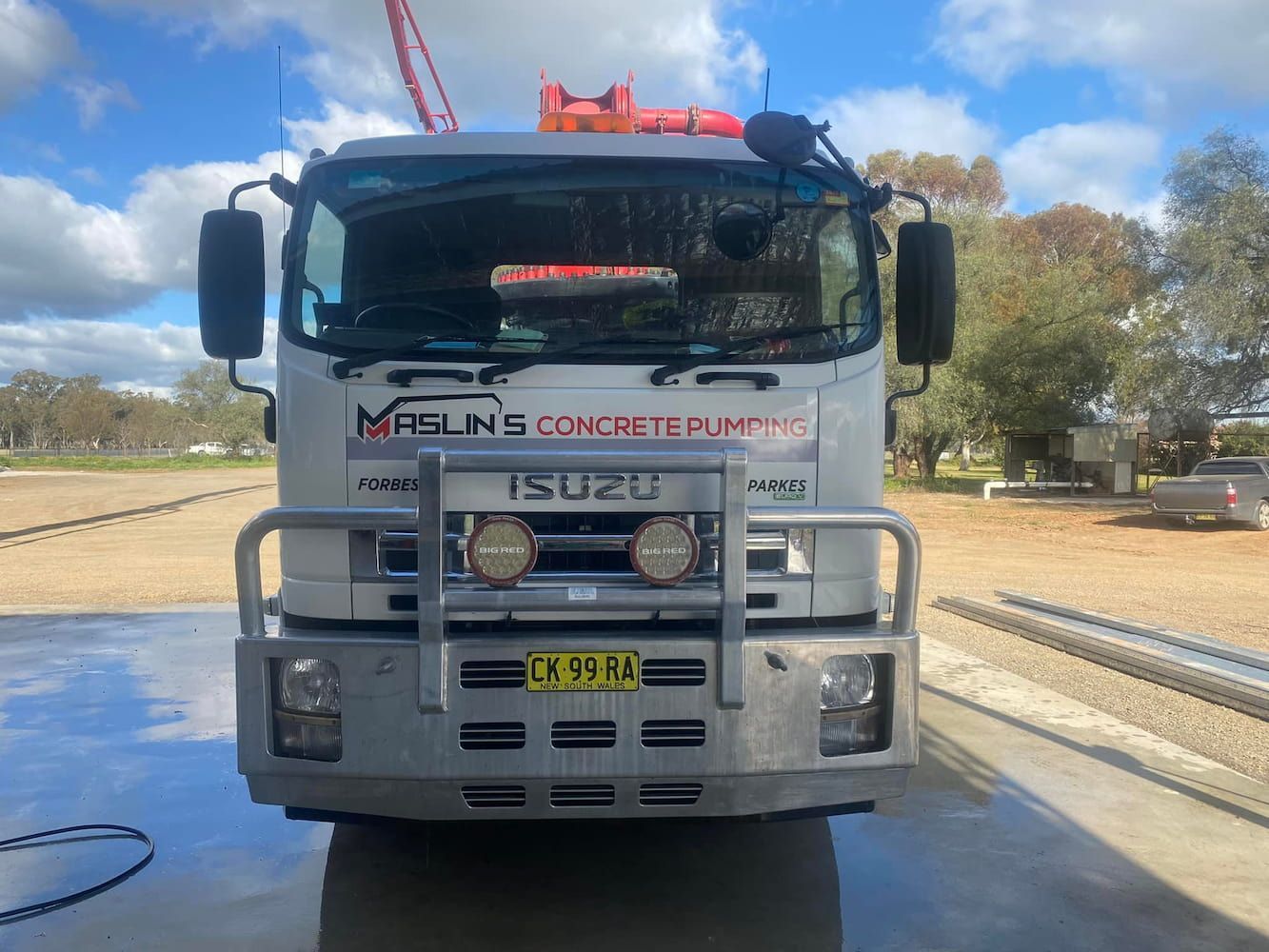 A Concrete Pump Truck Is Parked in A Parking Lot — Maslin Concrete Pumping in Parkes, NSW