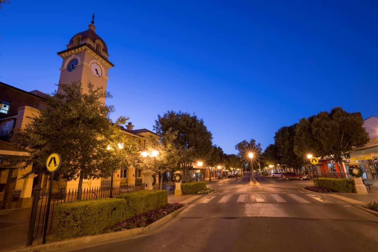 A Clock Tower Is in The Middle of A City at Night — Maslin Concrete Pumping in Dubbo, NSW