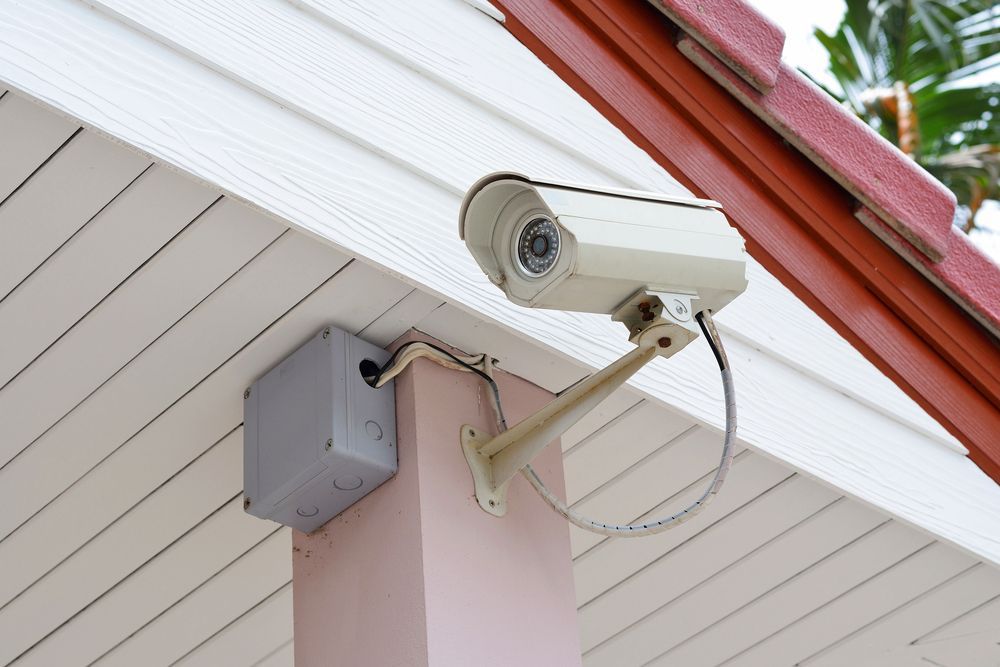 A White Security Camera Mounted to a Pink Pillar — OHMY Electrical Contractors in Carina, QLD
