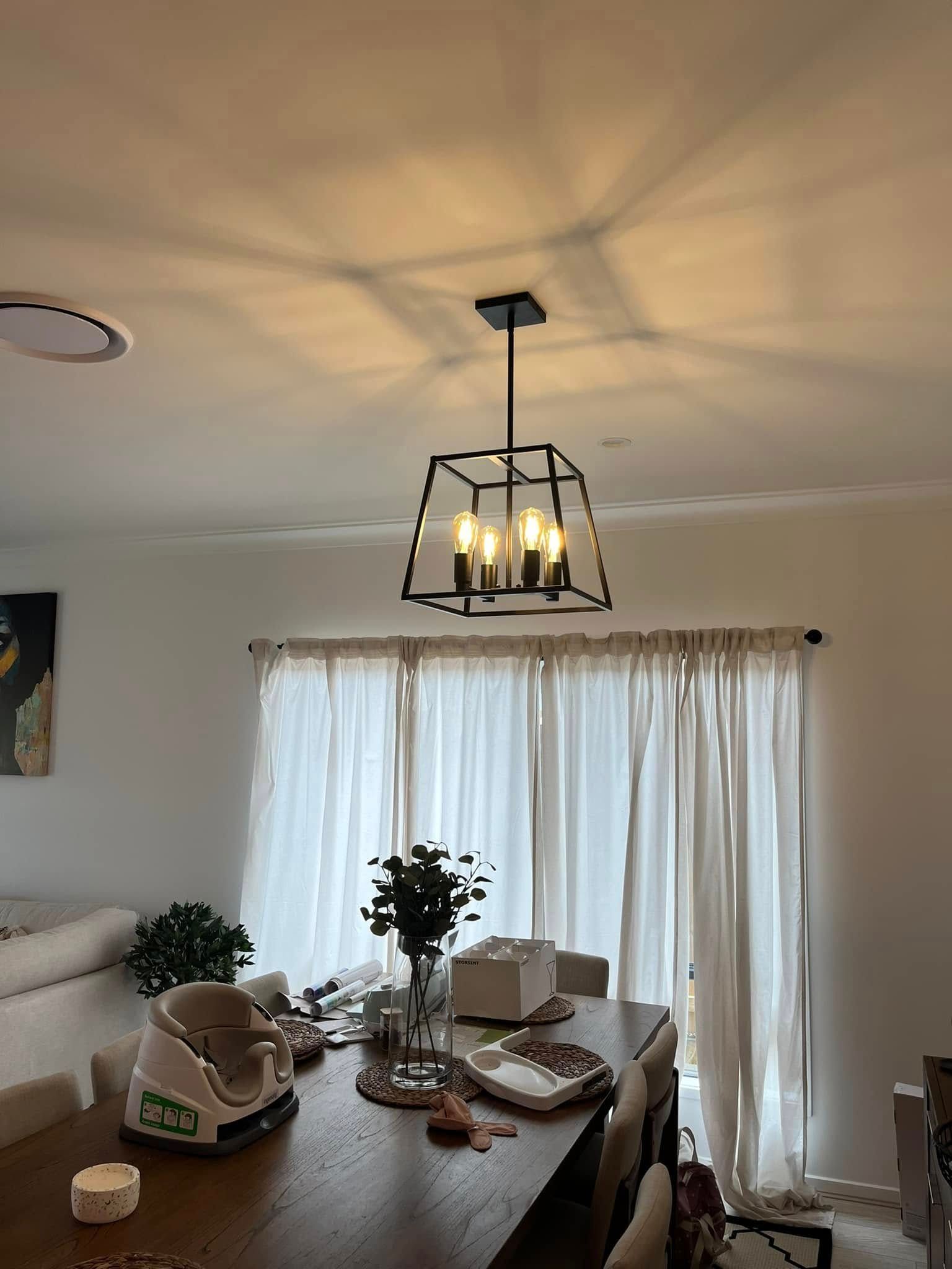 A Black Lantern-style Chandelier Hangs Above a Dining Table Set — OHMY Electrical Contractors in Carina, QLD