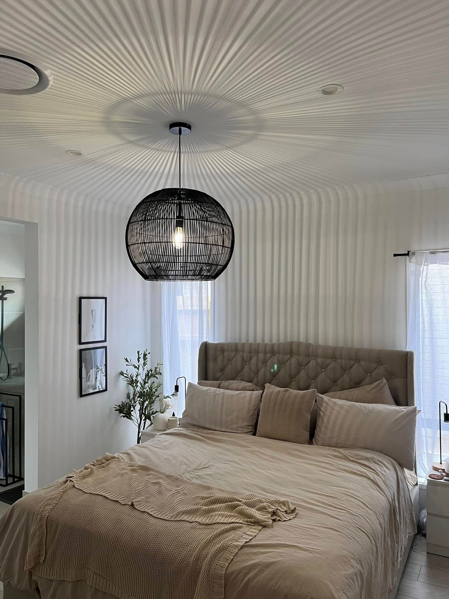 A Bedroom With a Tufted Headboard Bed and a Spherical Pendant Light — OHMY Electrical Contractors in Carina, QLD