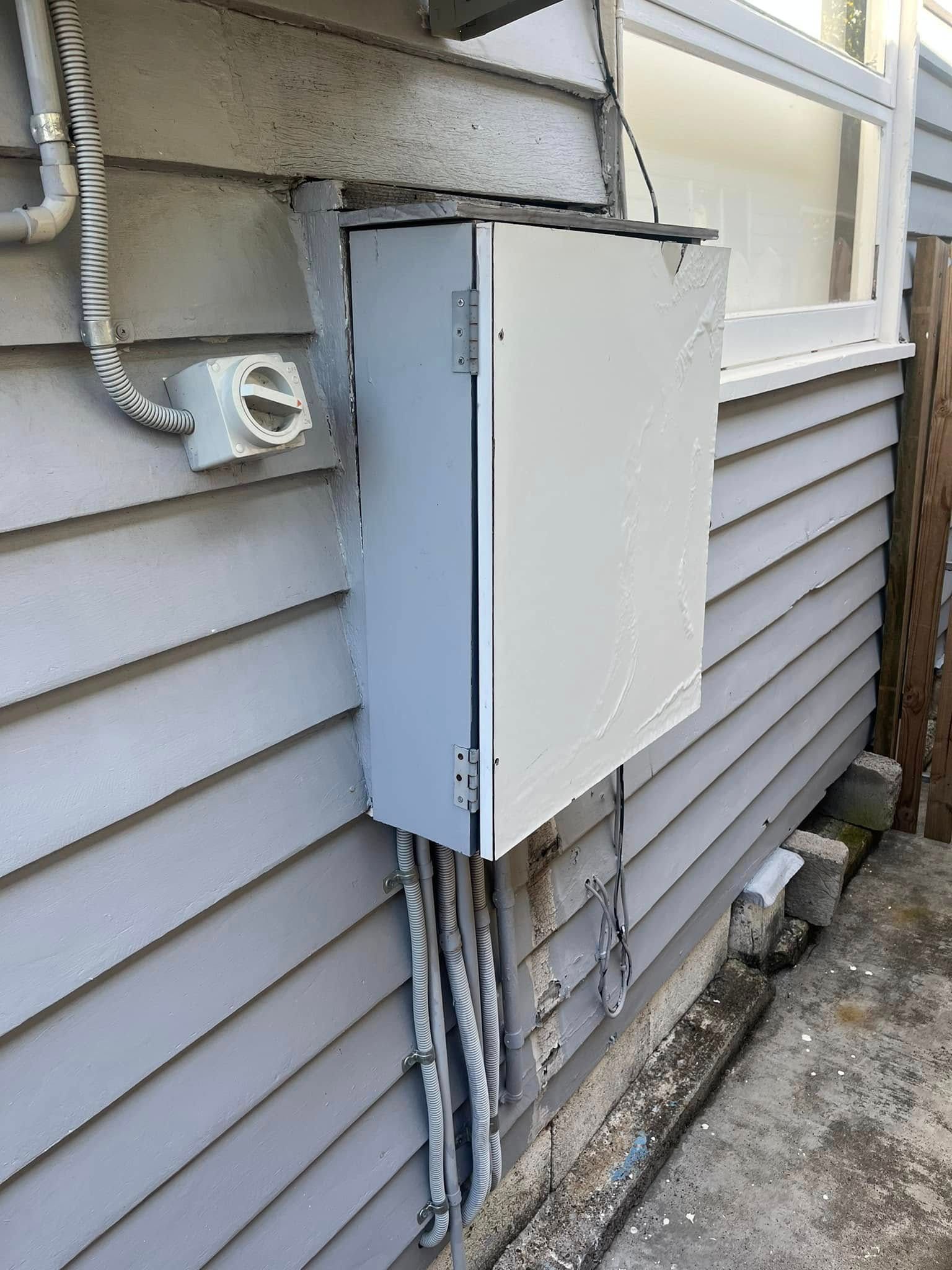 A Grey Electrical Box Mounted on the Exterior Wall of a House — OHMY Electrical Contractors in Carina, QLD