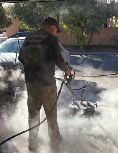 A man is using a pressure washer to clean a driveway.