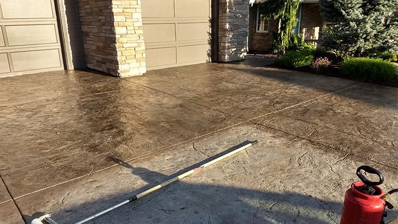 A person is using a mop to clean a sidewalk