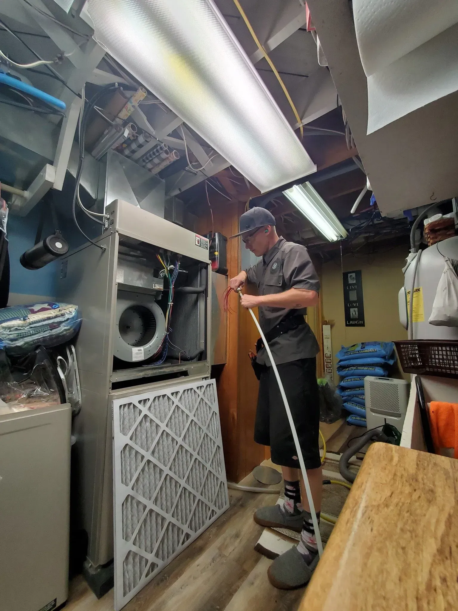 A man is working on a machine in a laundromat.