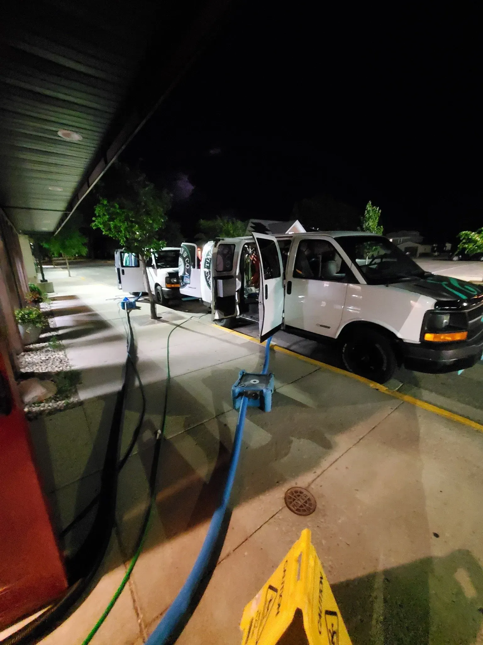 A white van is parked in a parking lot at night.