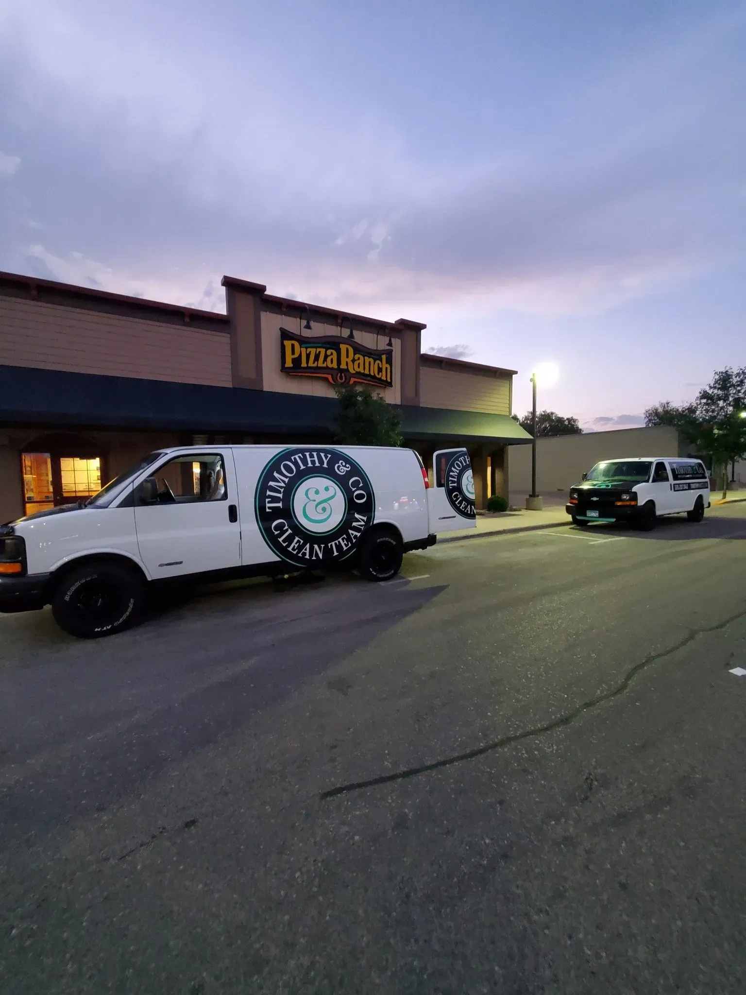 A white van is parked in front of a building.