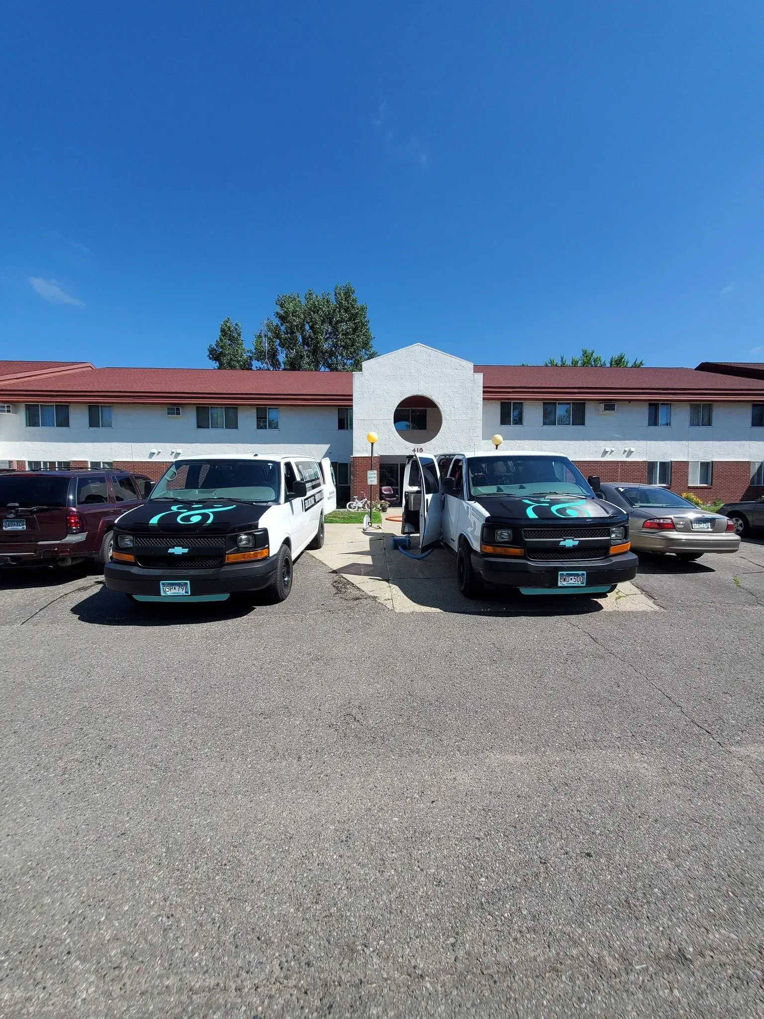 A row of cars are parked in front of a building.
