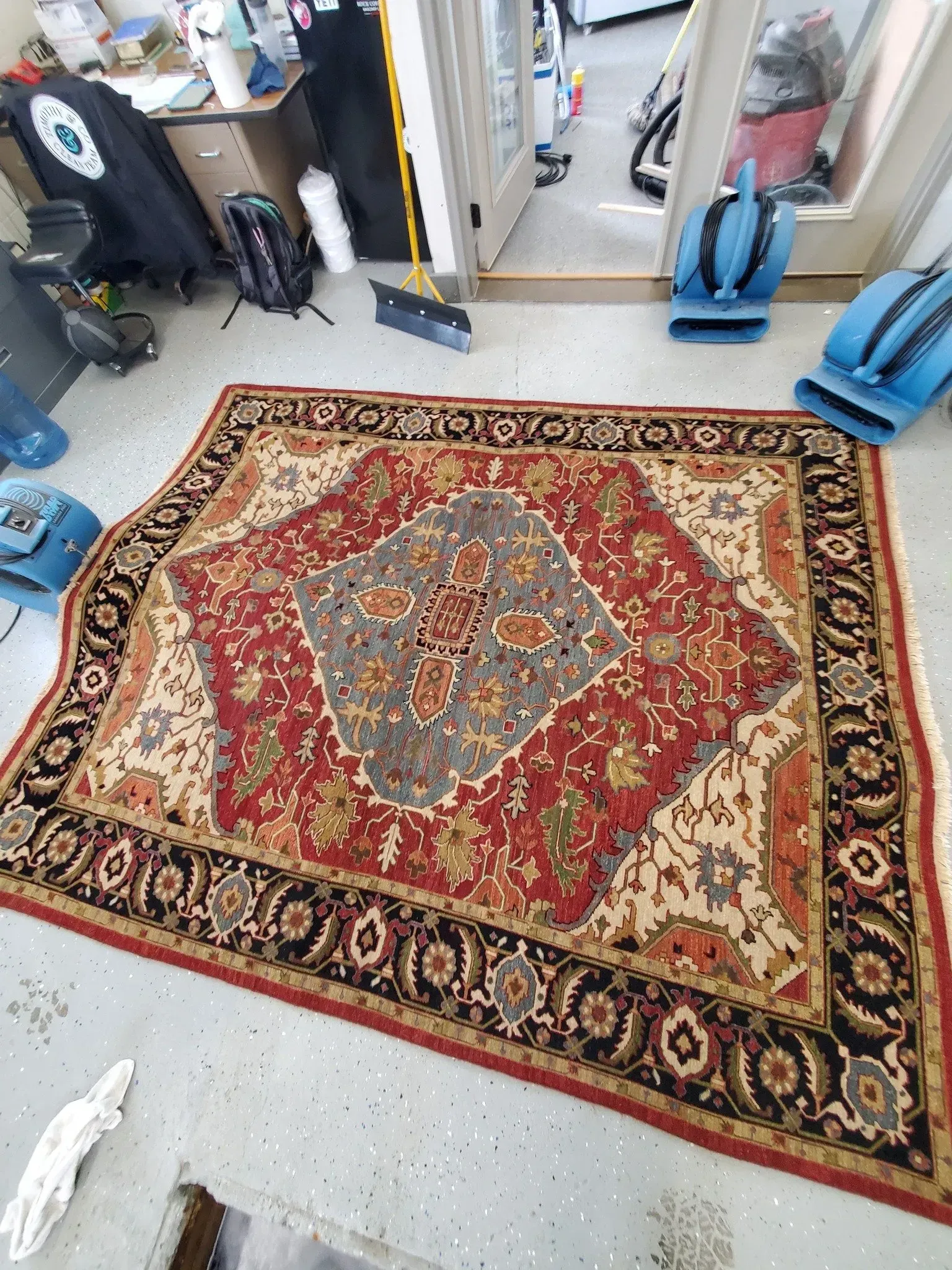 A large rug is sitting on the floor in a room.