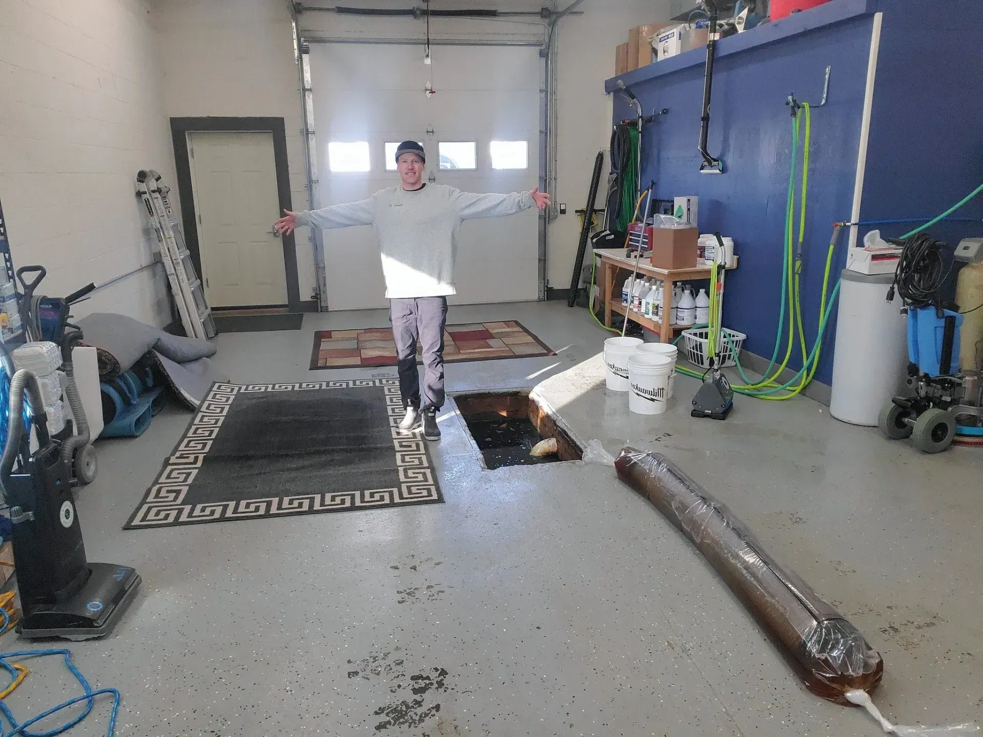 A man is standing in a garage with his arms outstretched.