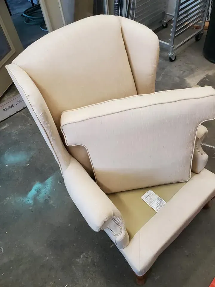 A white chair is sitting on a concrete floor in a room.