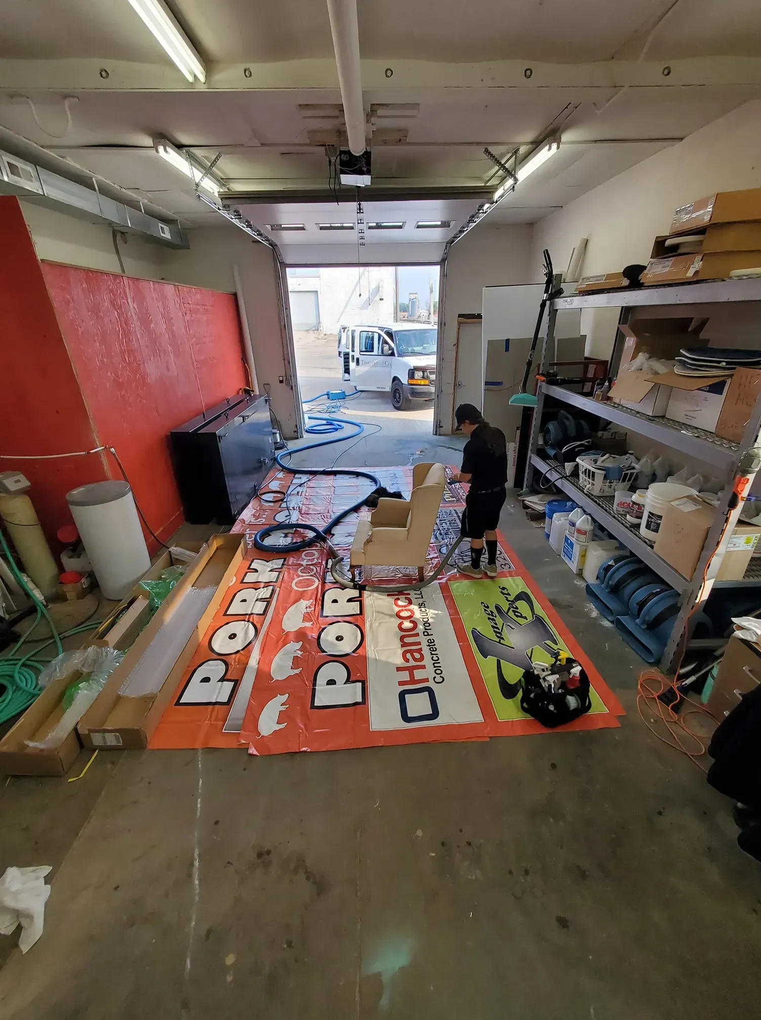 A man is working on a sign in a garage.