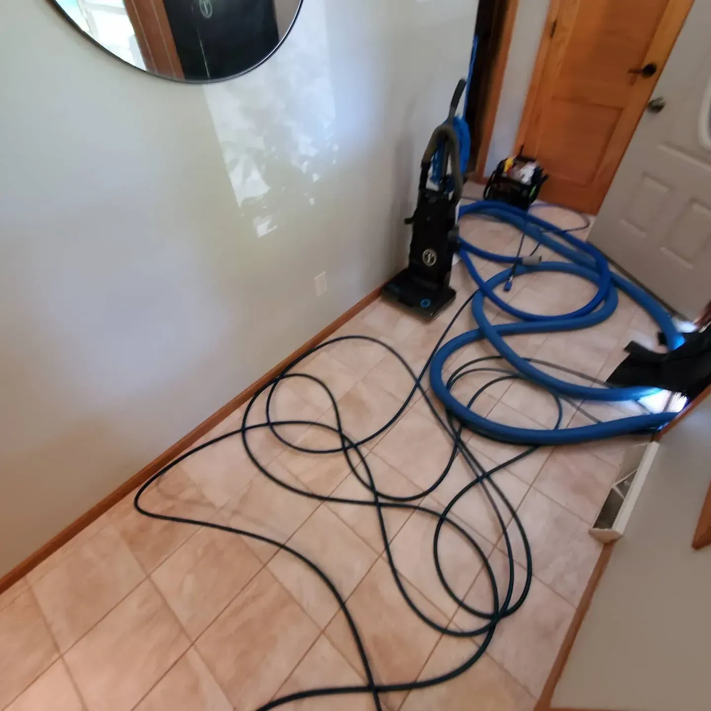 A vacuum cleaner is laying on the floor next to a mirror