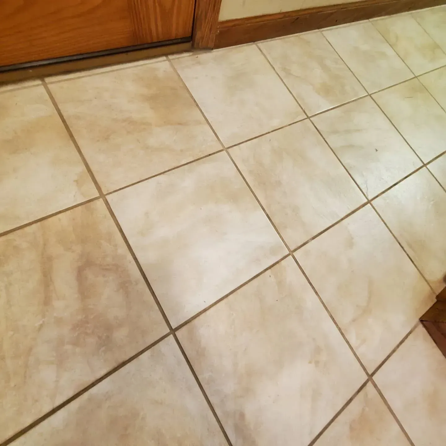 A tiled floor with a door in the background