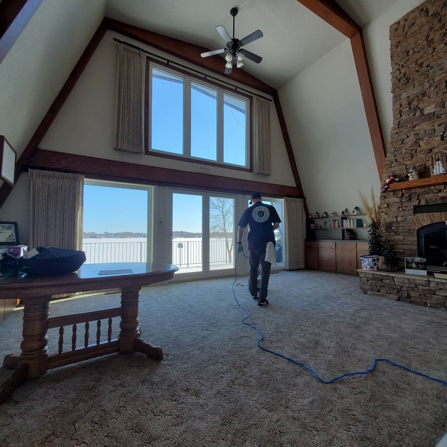 A man standing in a living room with a ceiling fan