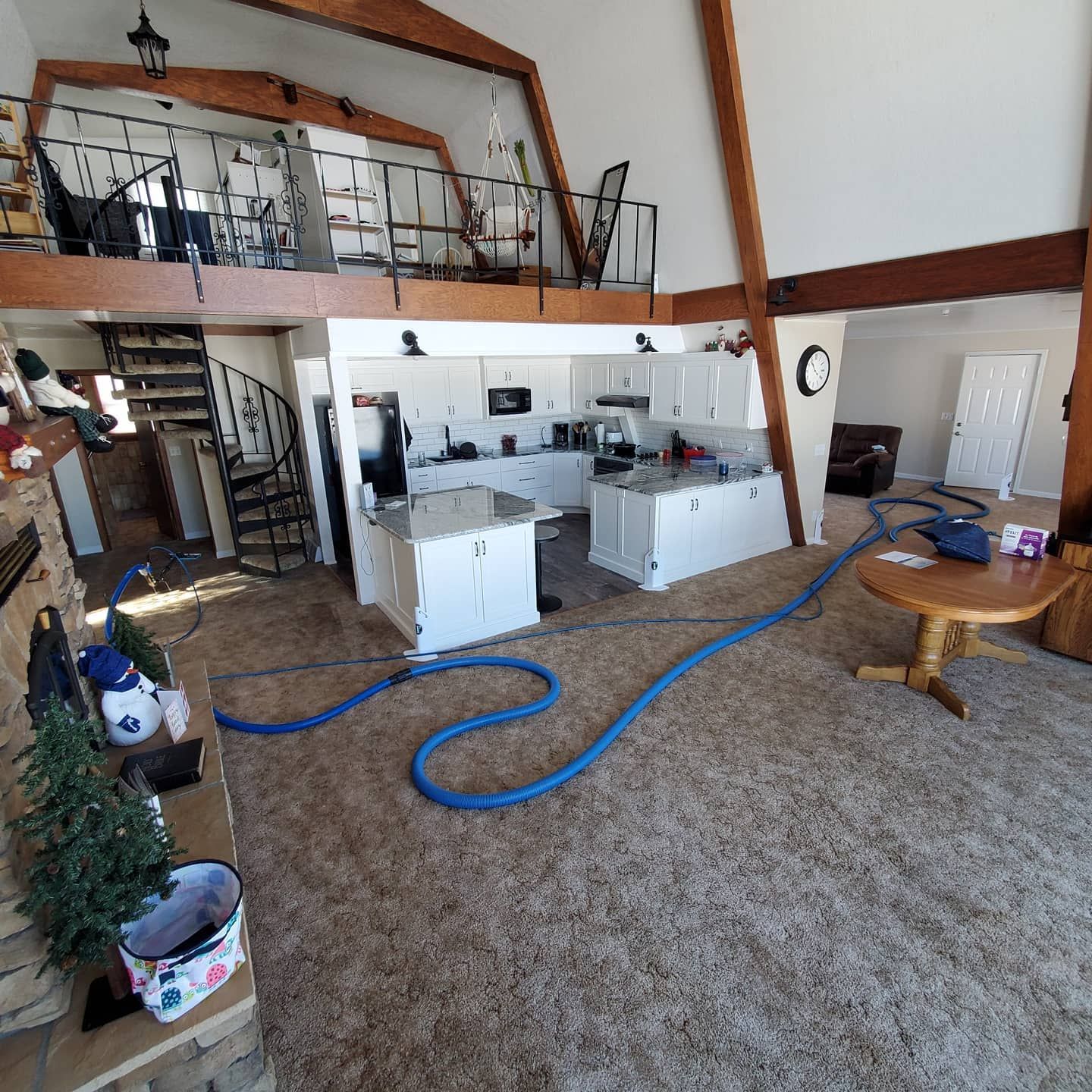 A living room with a kitchen and stairs and a table