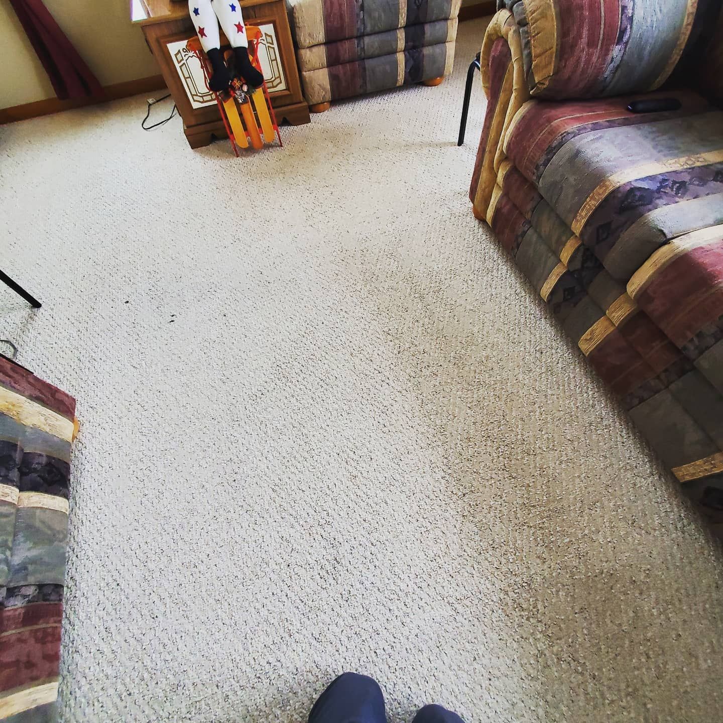 A living room with a couch and a nutcracker on the floor