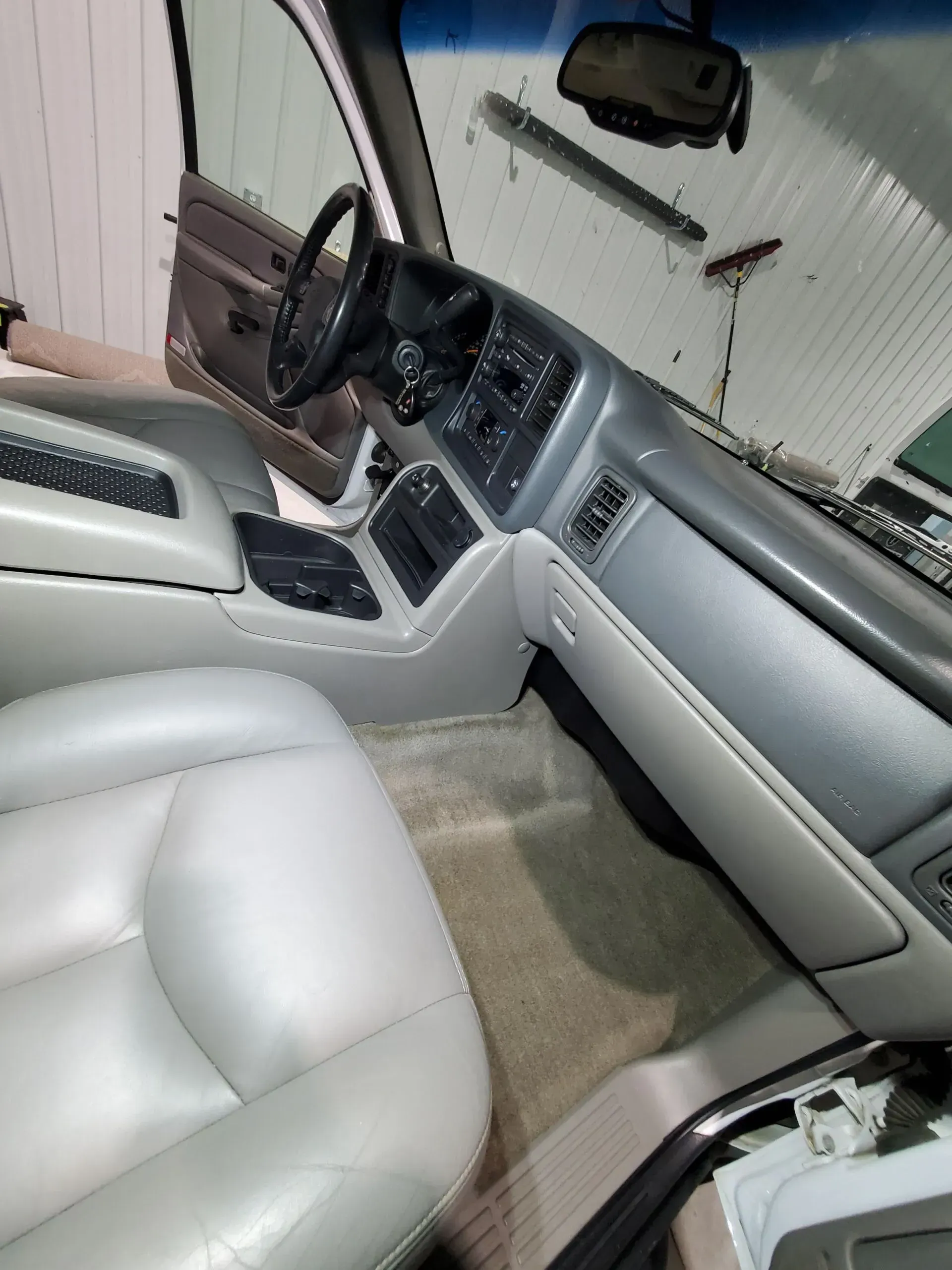 The interior of a silver car with white leather seats