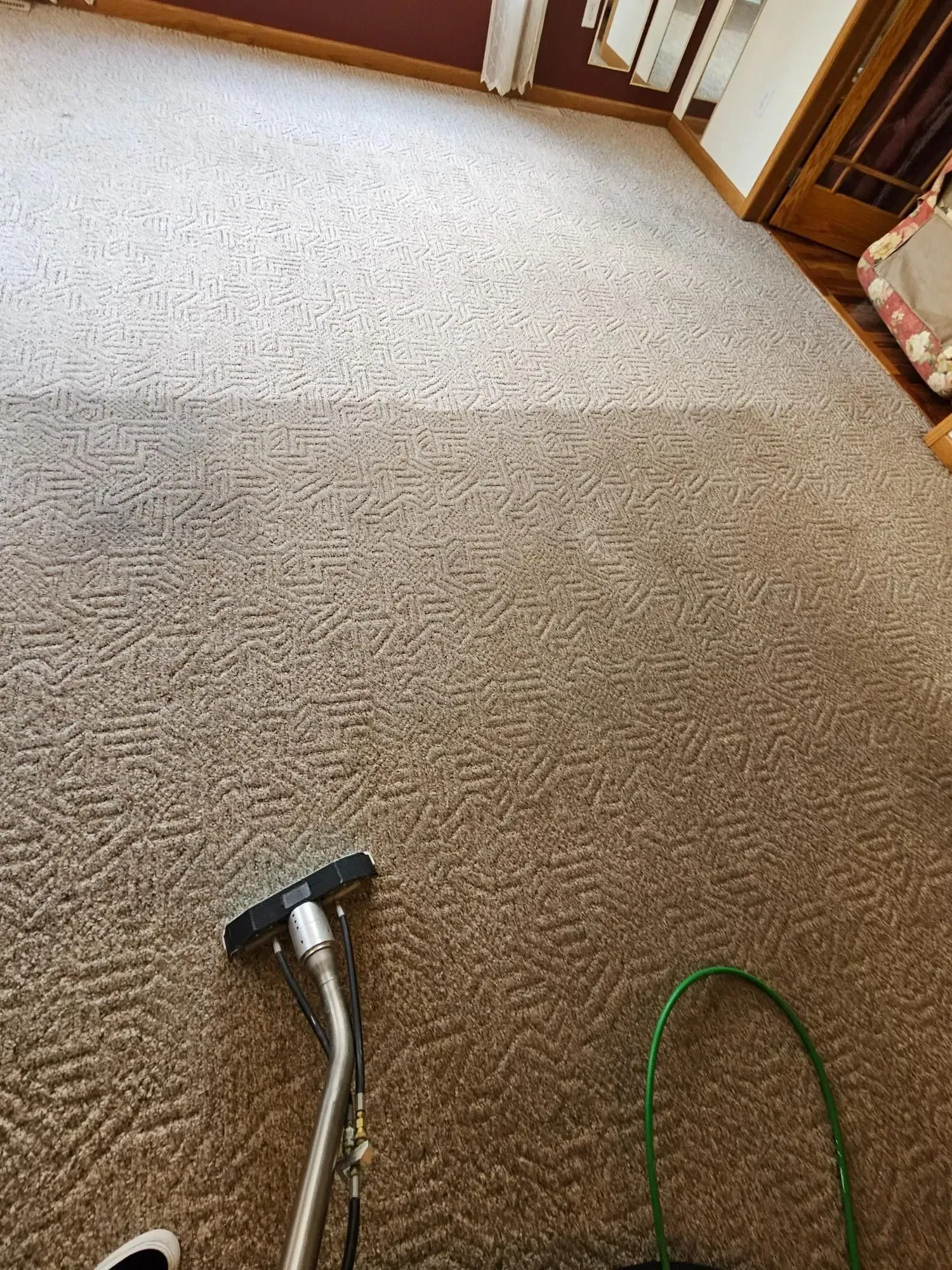 A vacuum cleaner is sitting on top of a carpet in a living room.