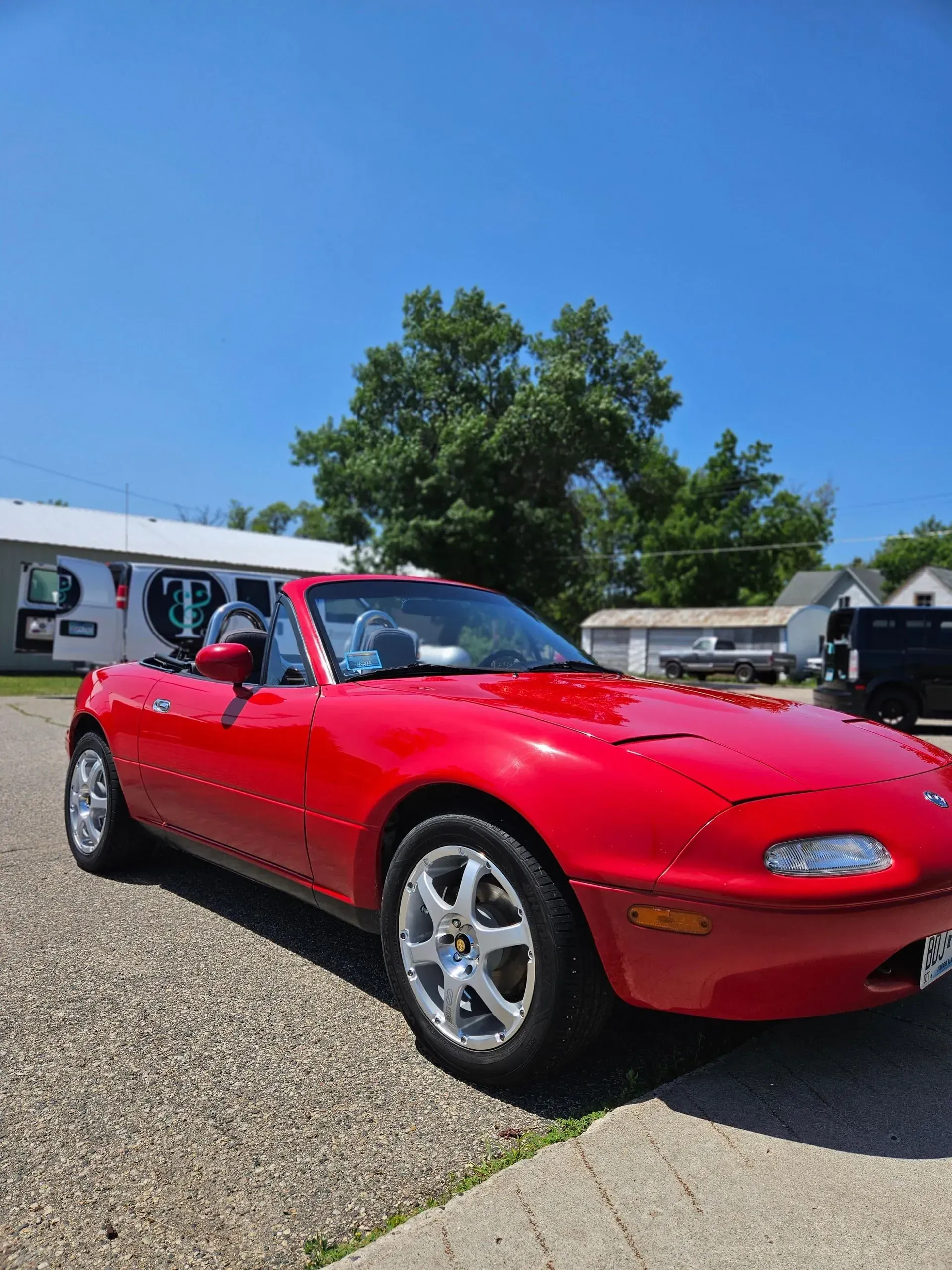 A red sports car is parked on the side of the road.