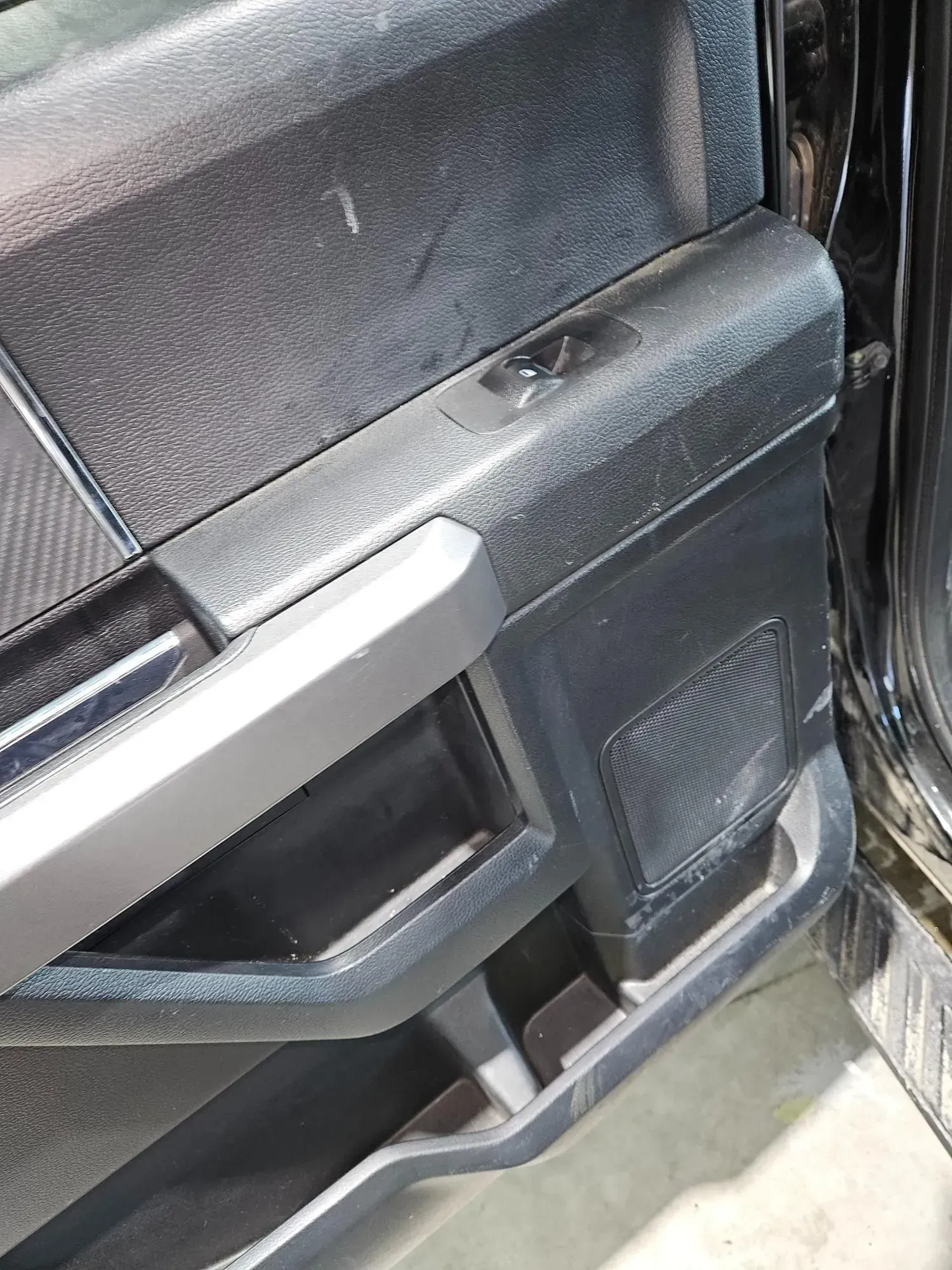 A close up of a door handle on a black car.