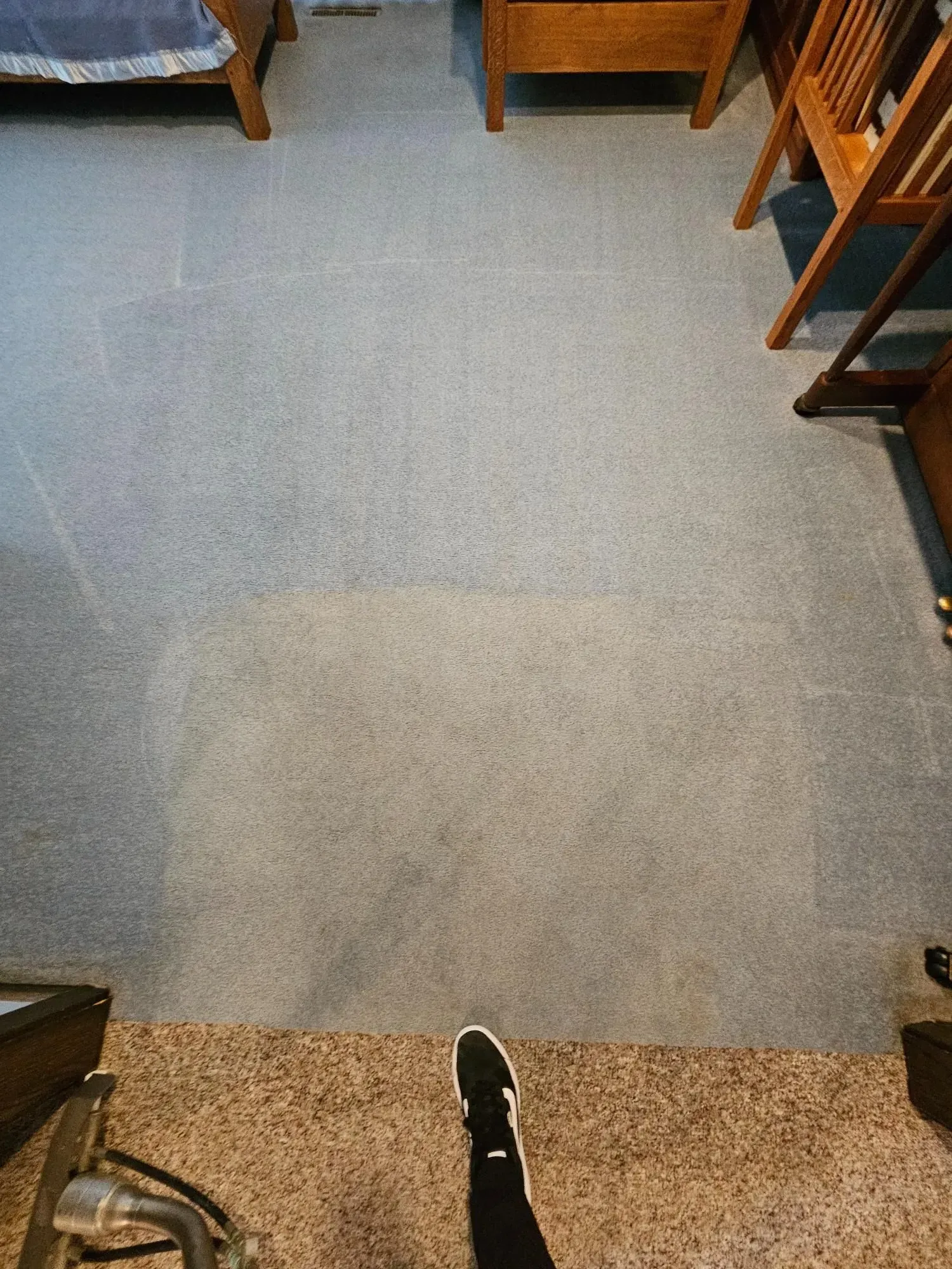 A person is standing on a carpeted floor in a room.